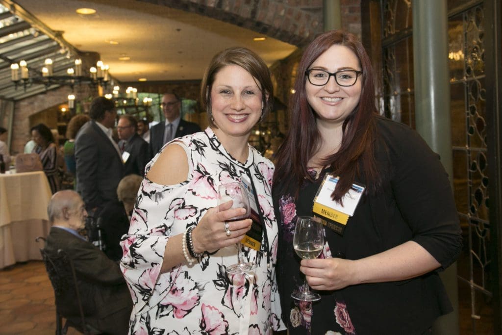Colleagues posing by glass doors, smiling