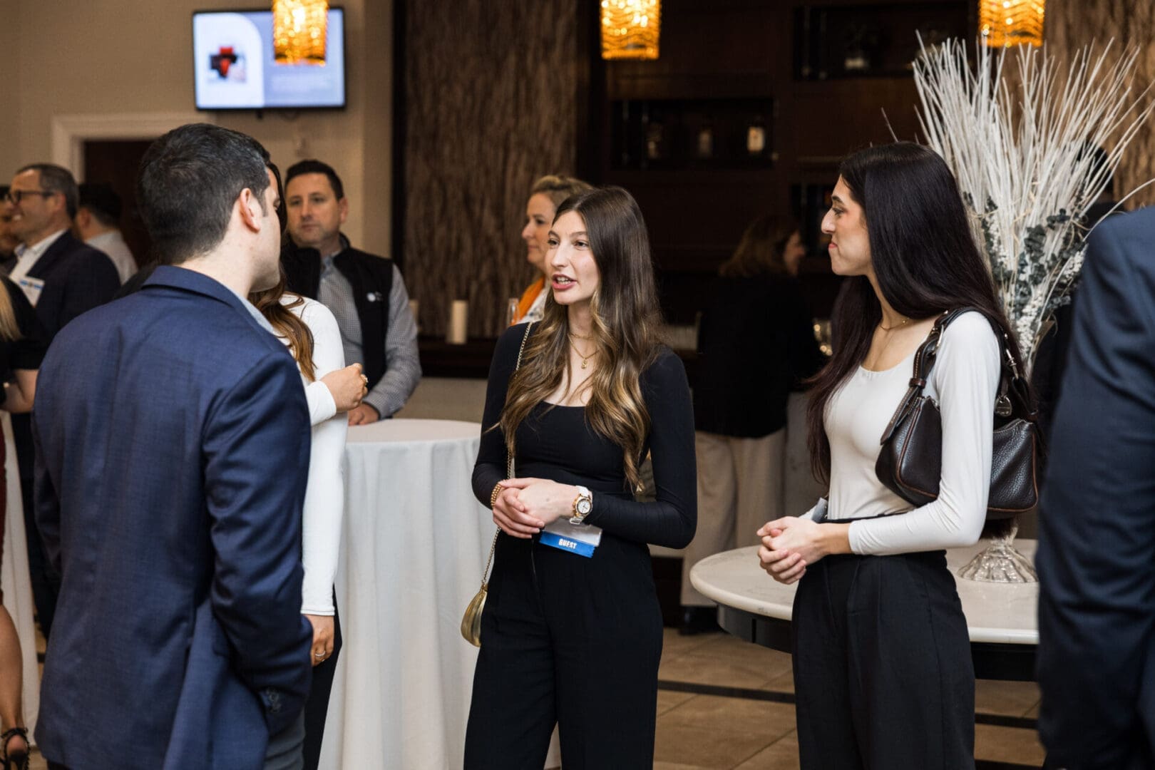 Three young professionals are networking at a business event.