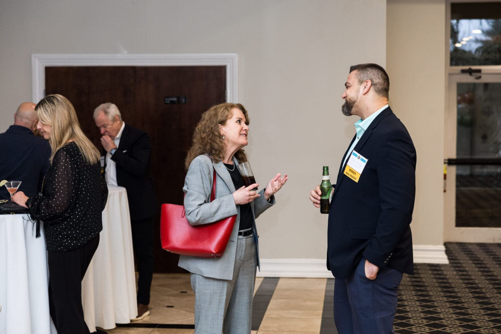 A man and woman in suits talking at an event.