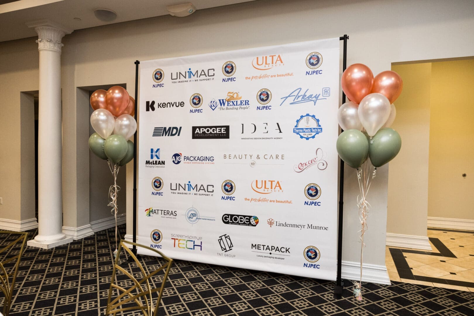 A step and repeat with corporate logos and balloons.