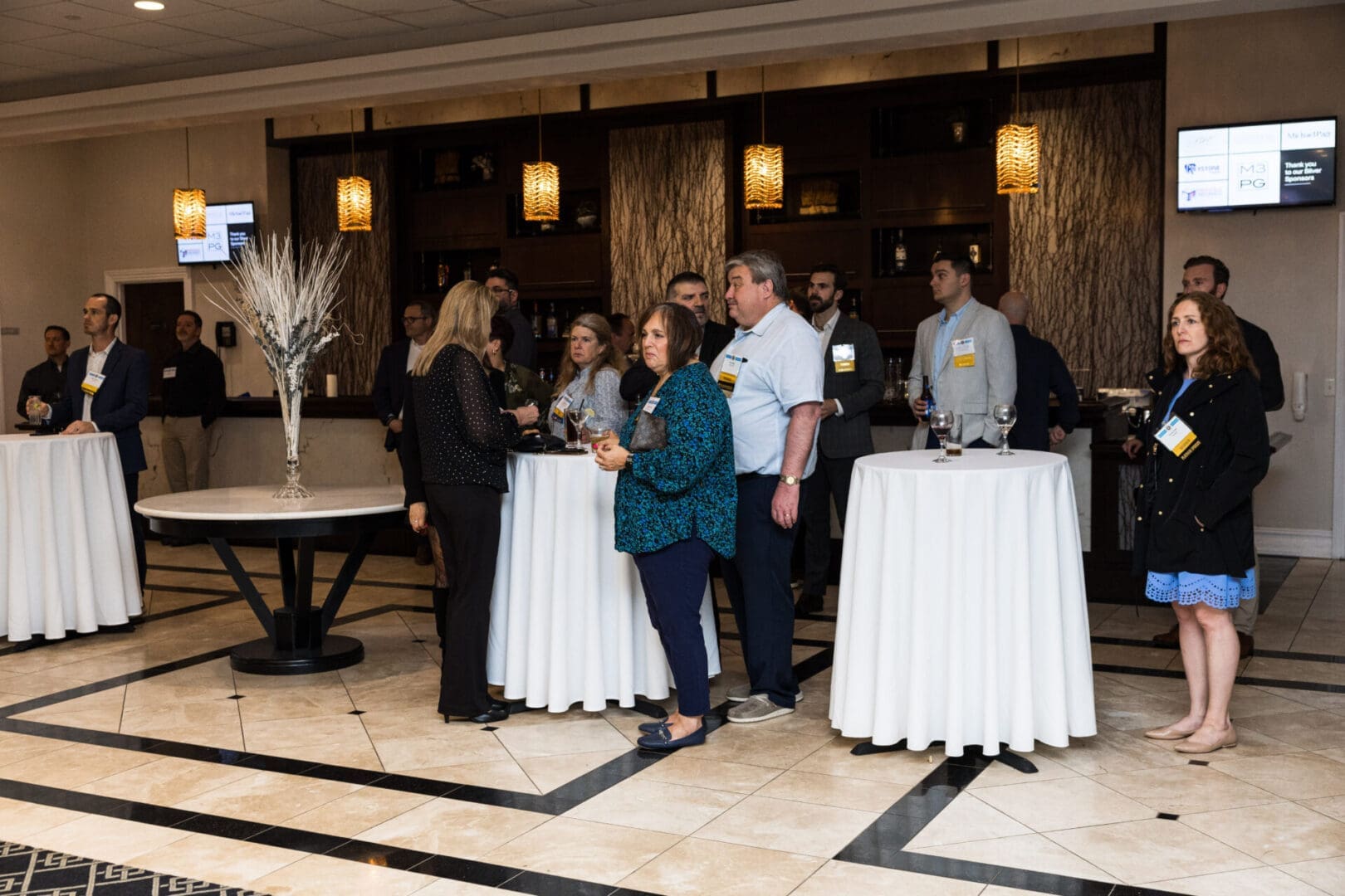 A group of people standing around tables in a room.