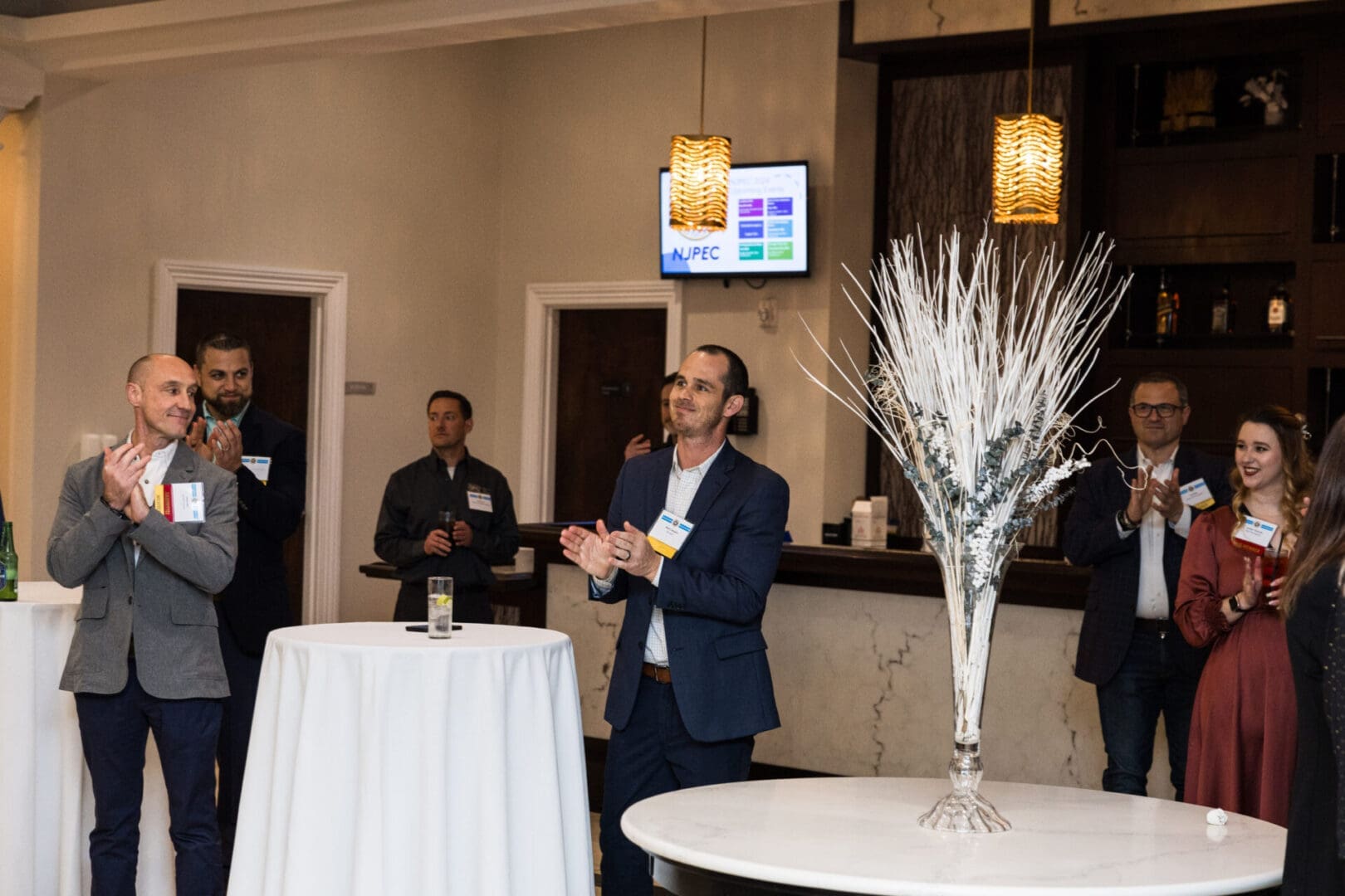 Business professionals applaud at a networking event.