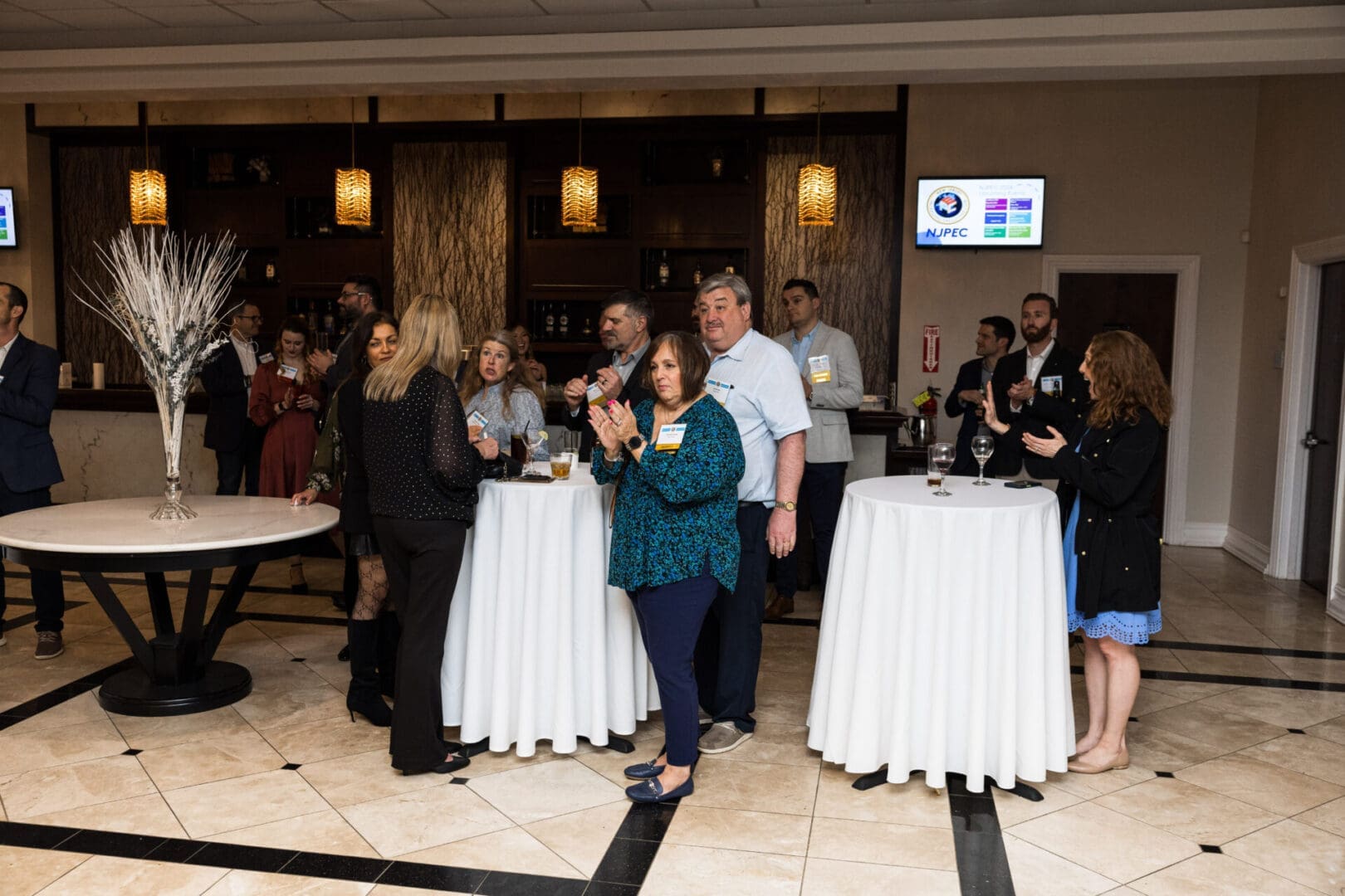 A group of people are standing and talking in a room.