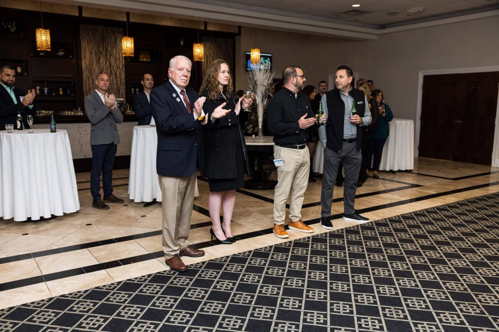 Business professionals applaud at a networking event.