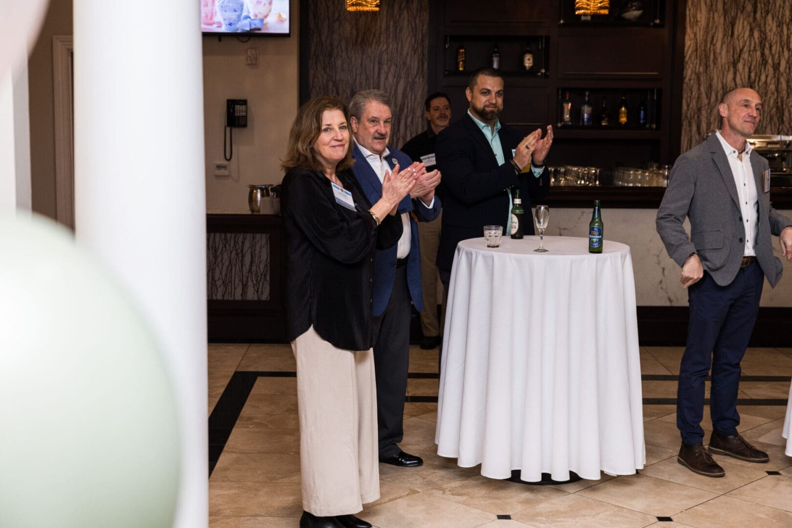 Business professionals applaud at a networking event.