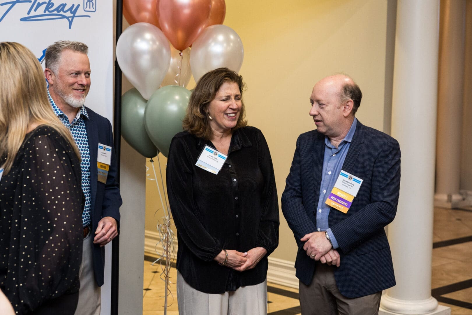 Three people are networking at a conference.