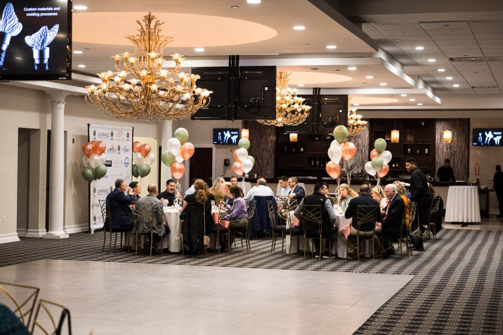 A group of people are sitting at tables in a large room.