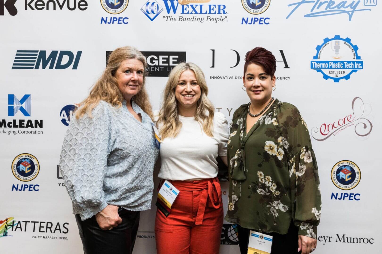 Three women posing for a photo at an event.