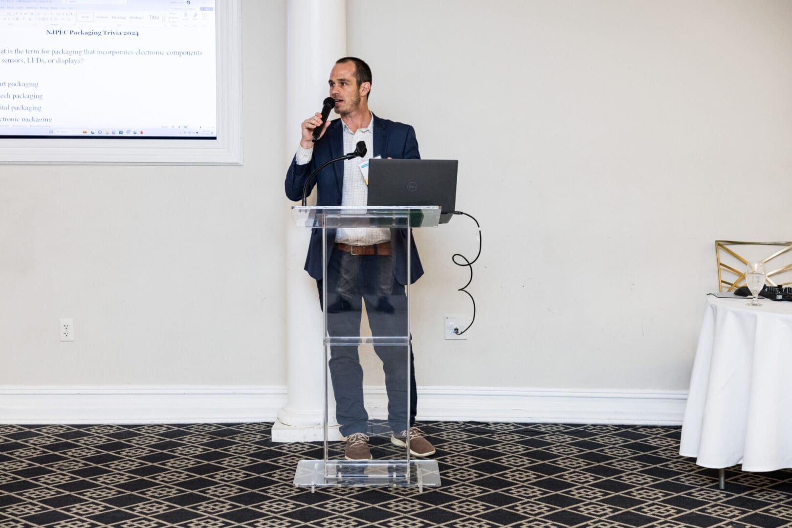 Man speaking at a podium with a laptop on it.