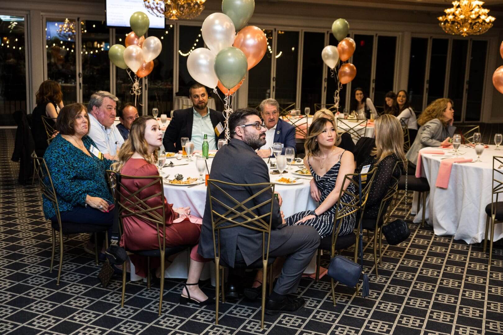 A group of people are sitting at a table having dinner.
