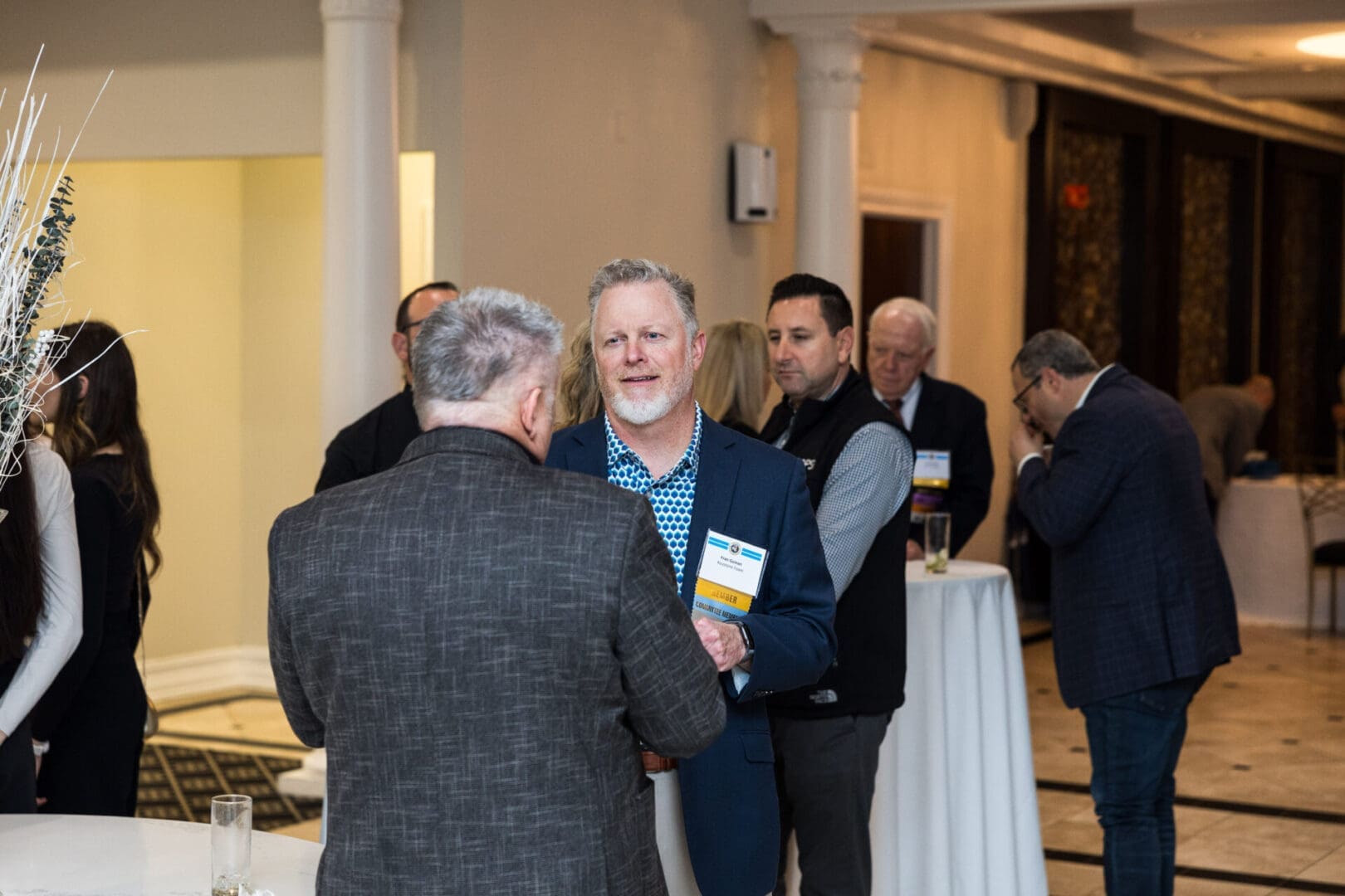 Businessmen in suits talking at a networking event.