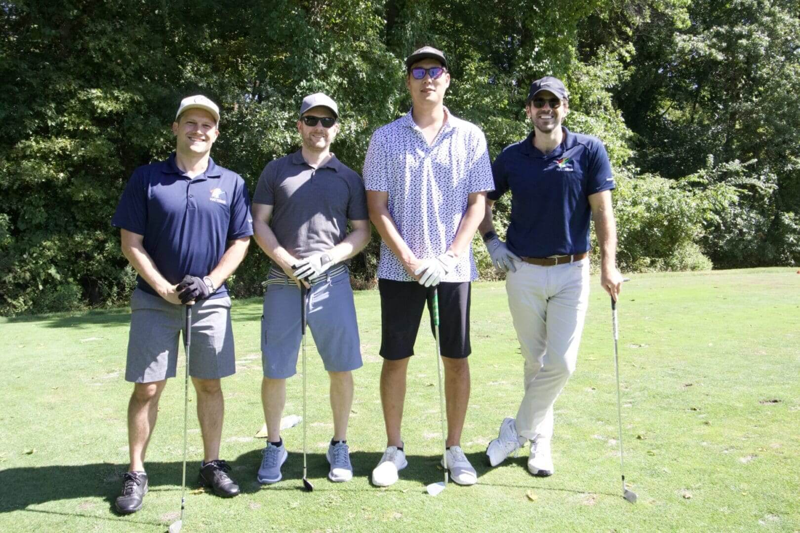 Four golfers on a sunny course.
