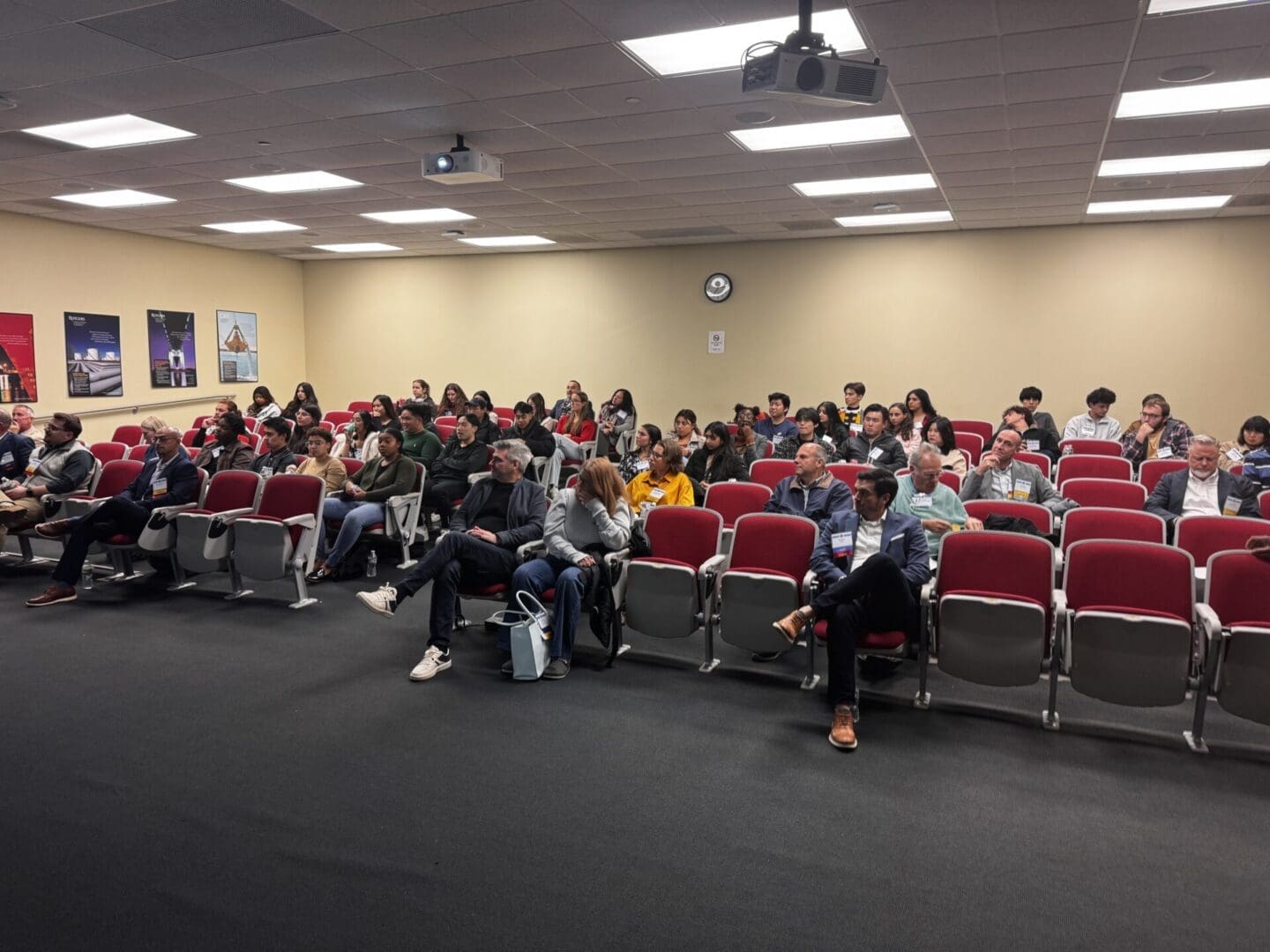 Audience seated in a conference room.