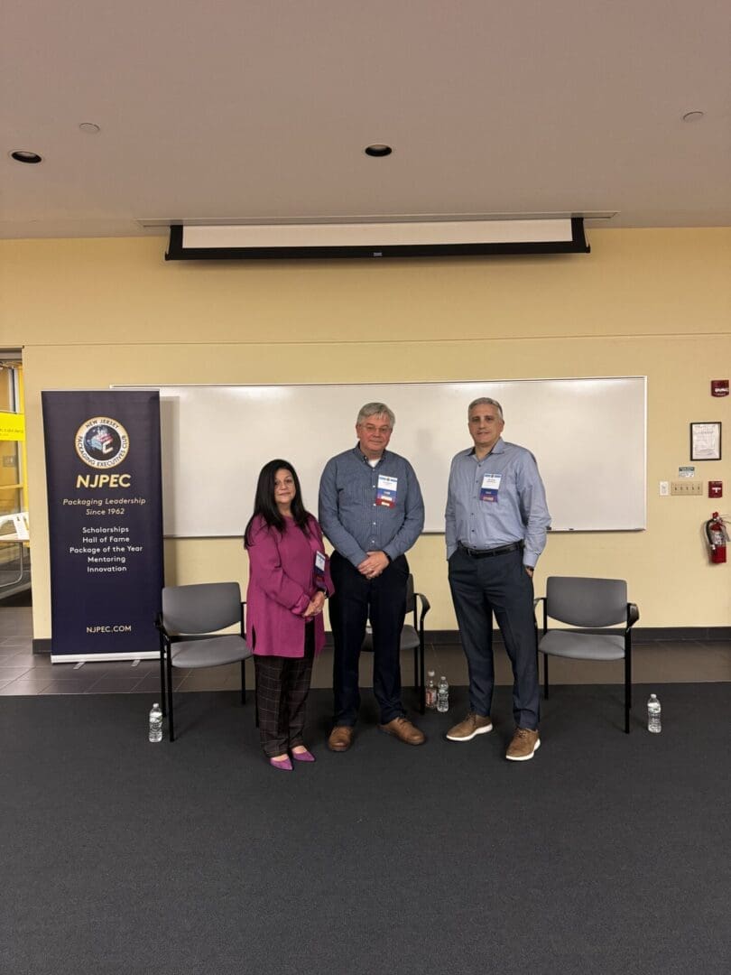 Three people standing in a conference setting.
