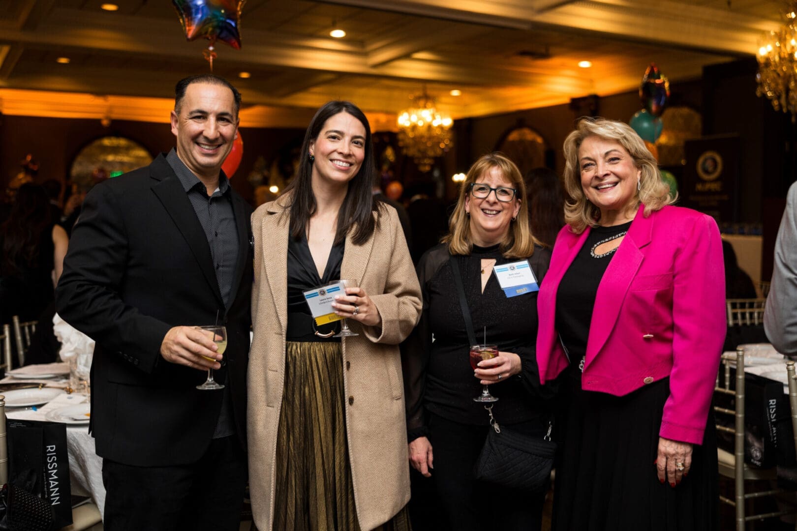 Four people smiling at a celebration event.