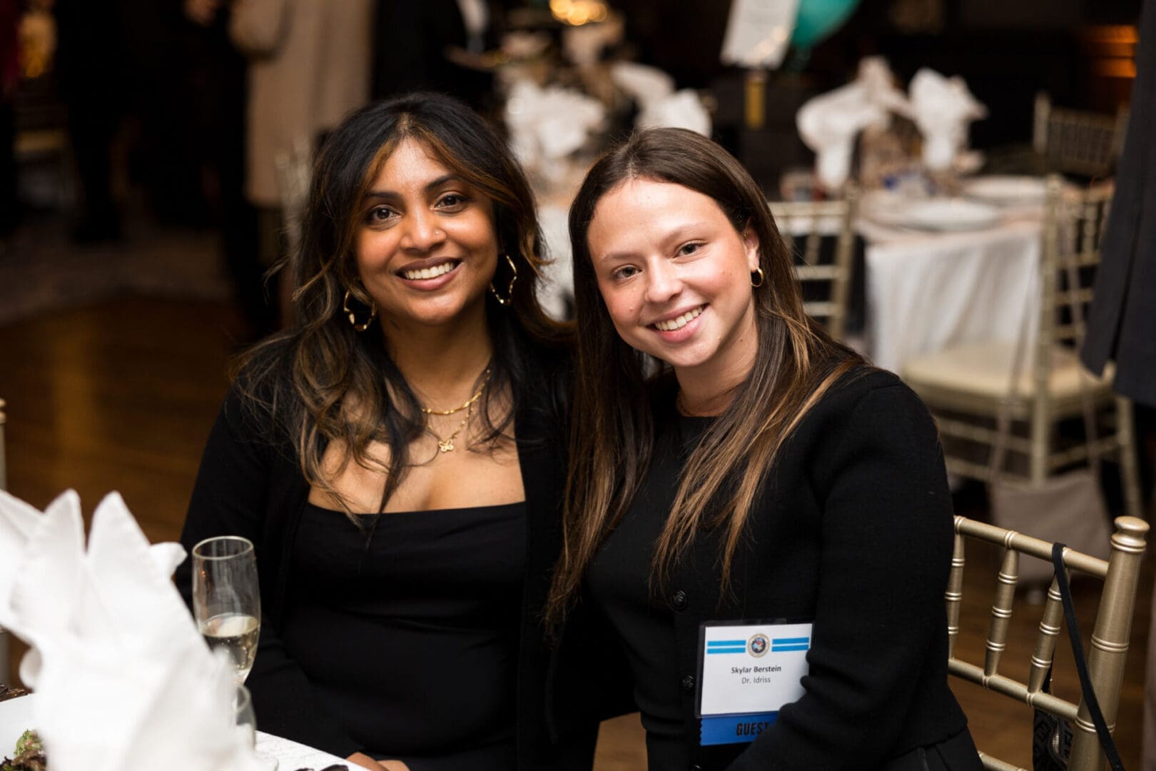 Two women smiling at an event.
