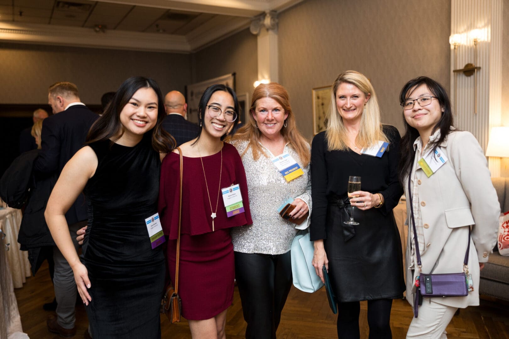 Five women posing at a social event.
