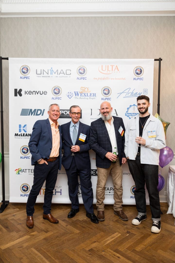 Four men at an event standing together.