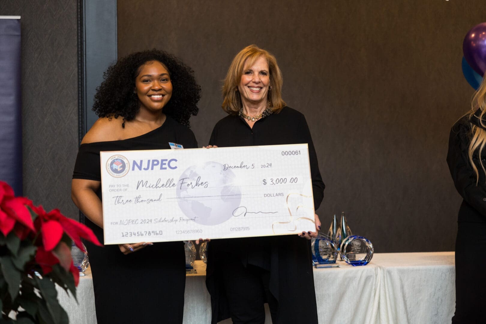 Scholarship awardees holding a large check.