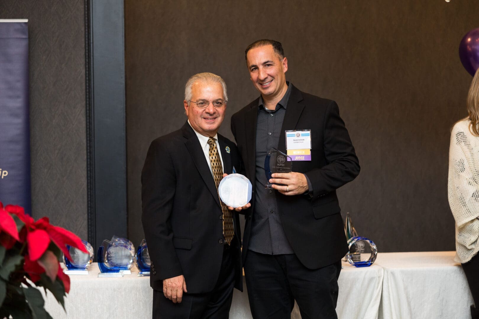 Two men holding awards at an event.