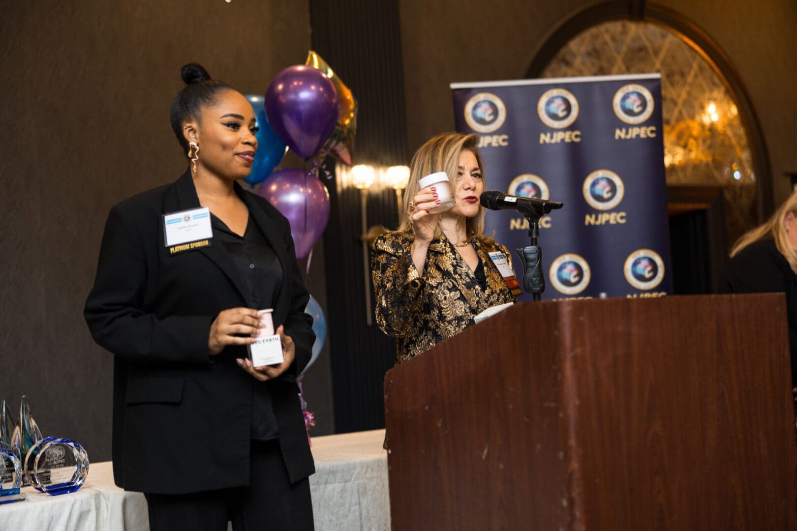 Two women speaking at a podium event.