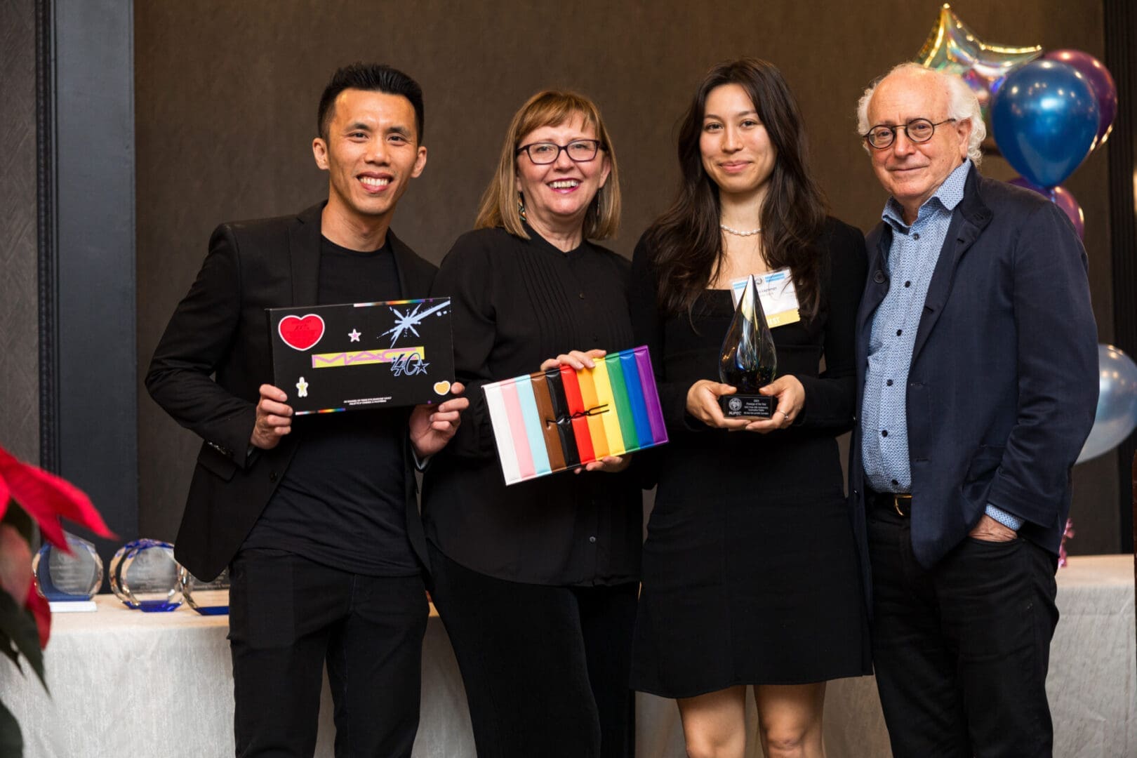 Group photo celebrating achievements with awards.