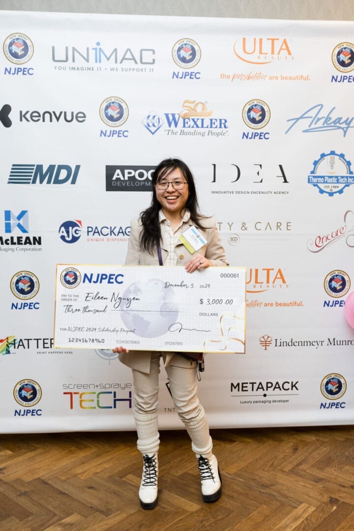 Young woman holding a scholarship check.