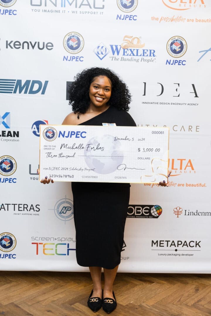 Winner holding scholarship check at event.