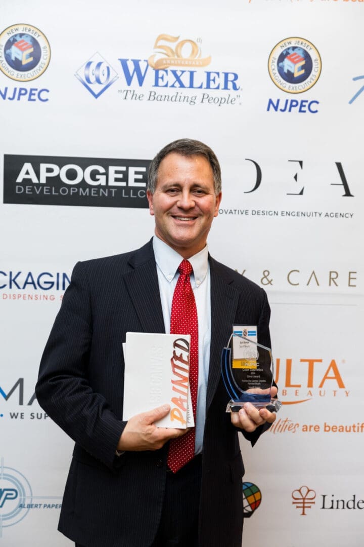 Man holding an award and a book.