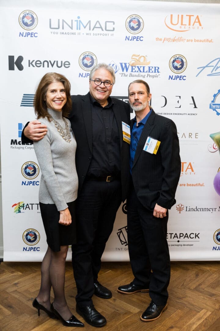 Three people posing at a professional event.