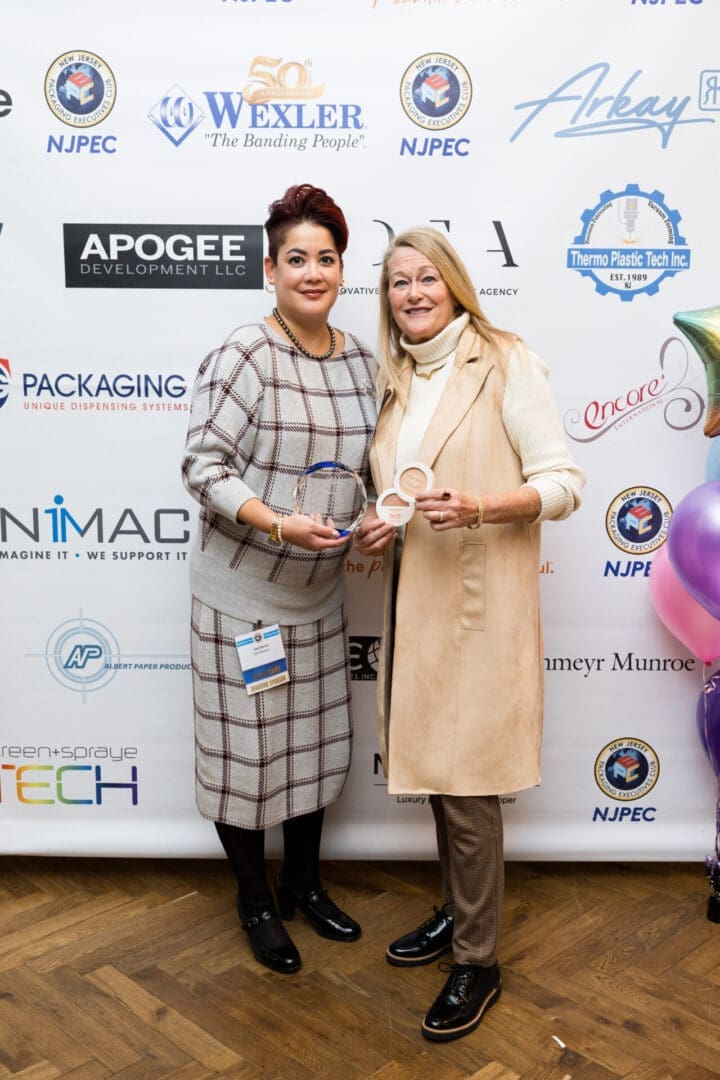 Two women holding awards at an event.