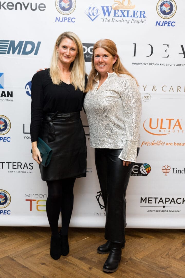 Two women posing at a red carpet event.