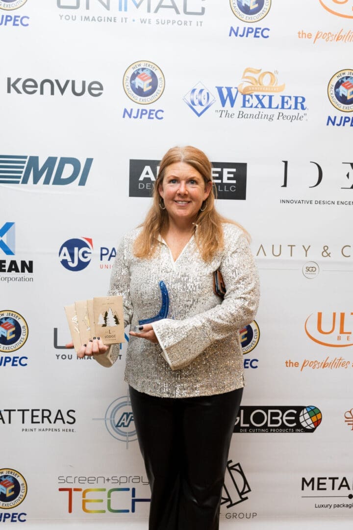 Woman holding awards in a glittery outfit.