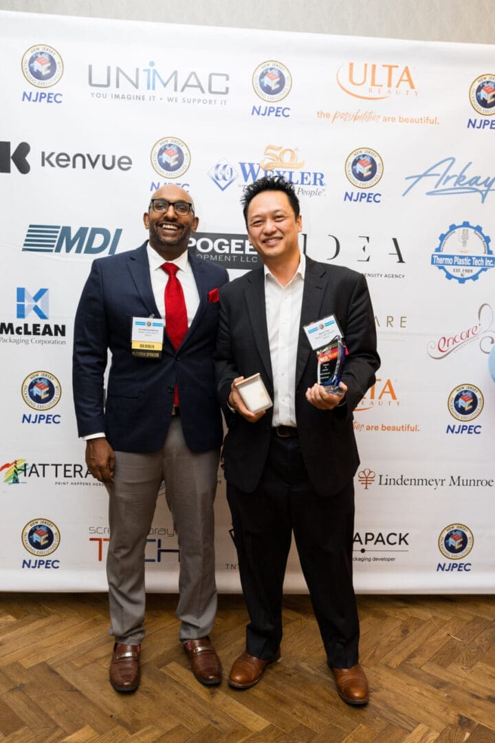Two men posing at an awards event.
