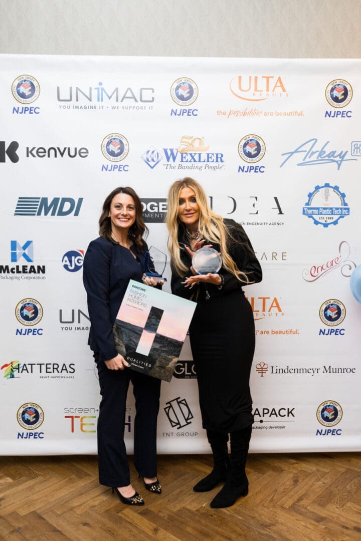 Two women holding an award and poster.