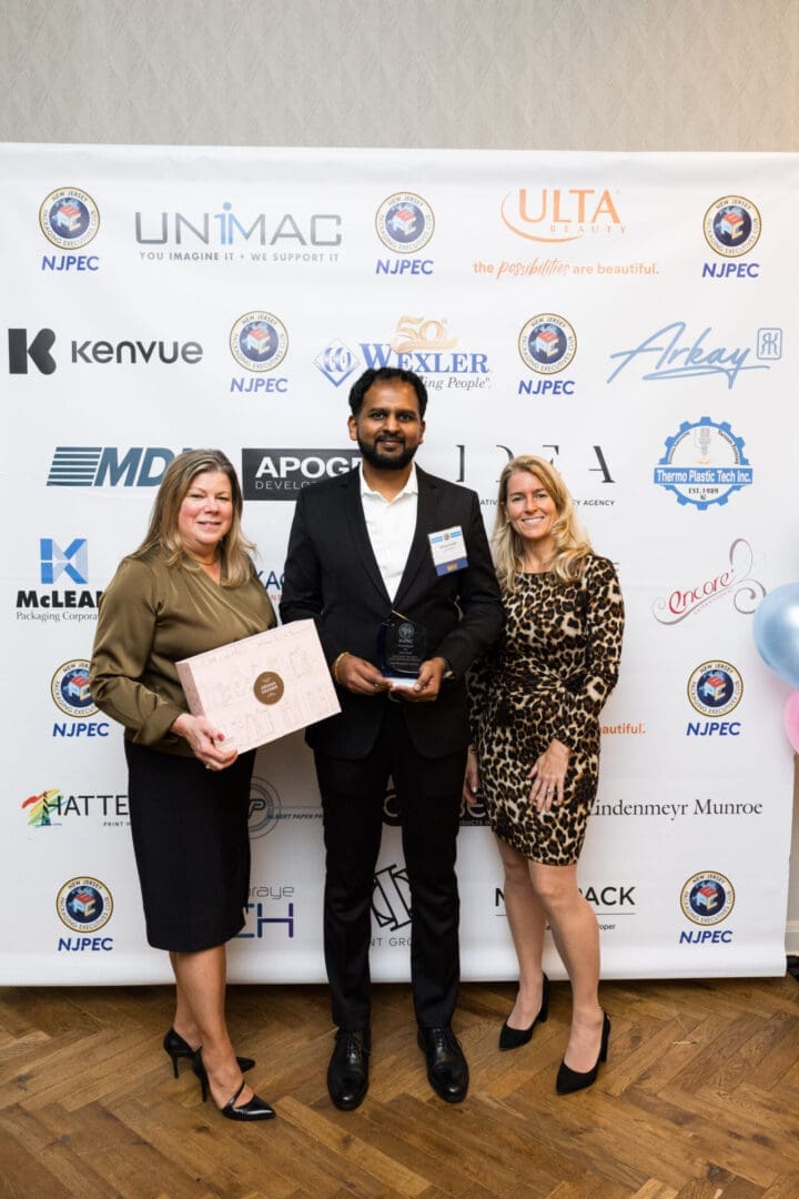 Three people at an award ceremony event.