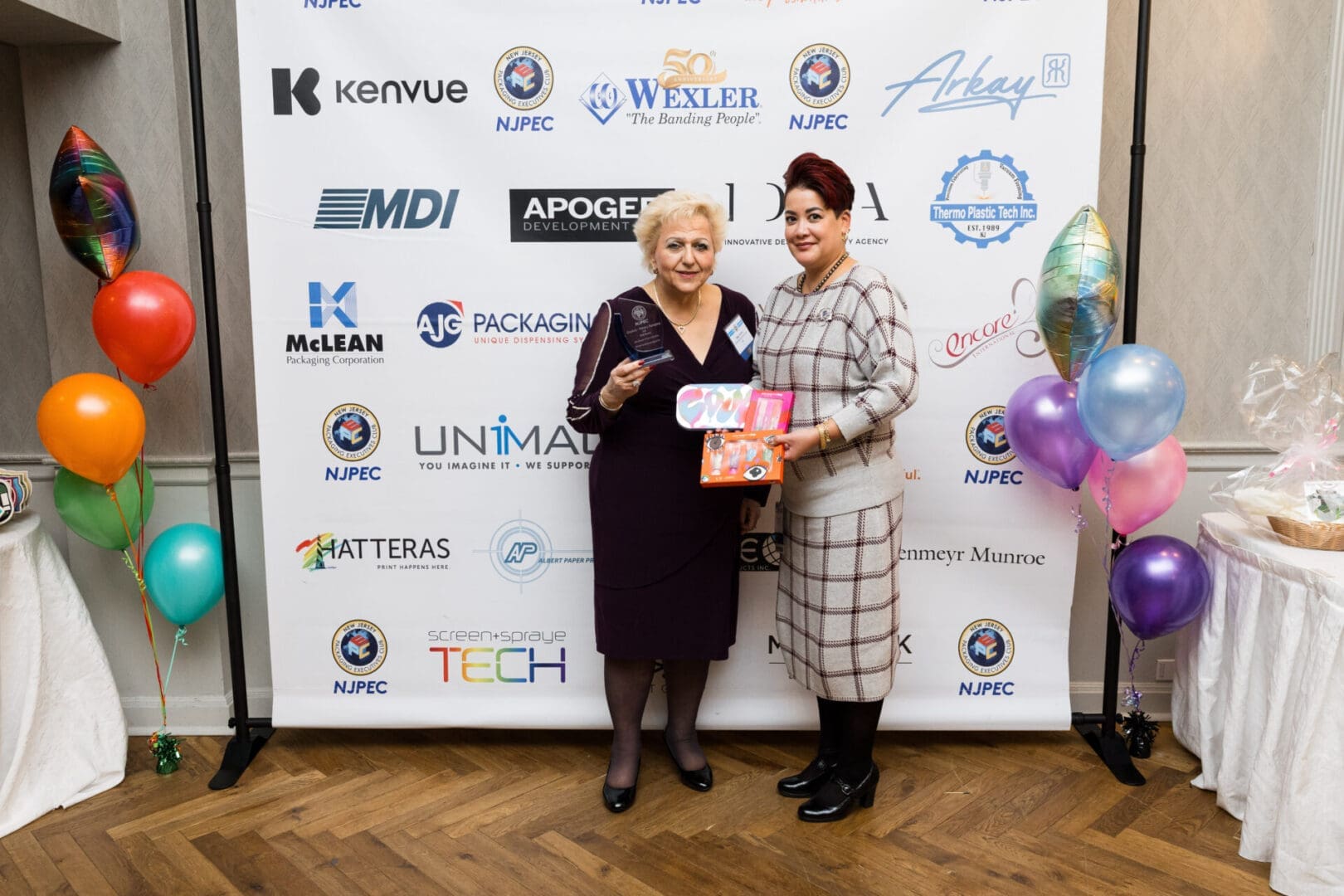 Two women holding awards at an event.