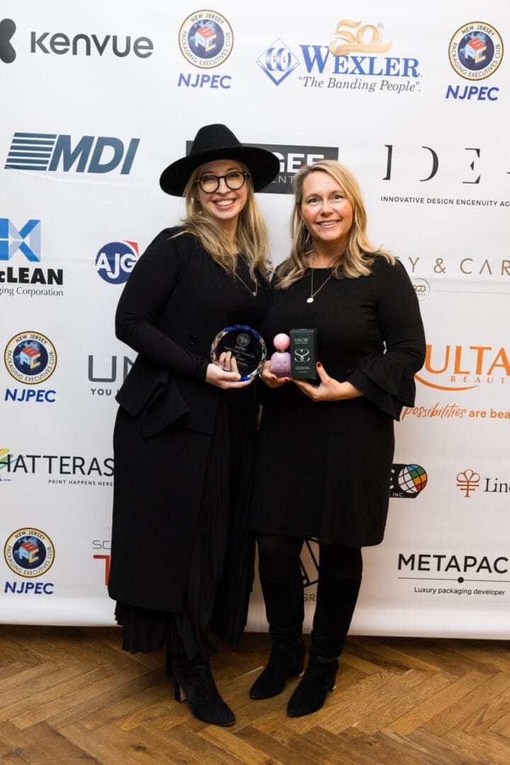 Two women holding awards at an event.