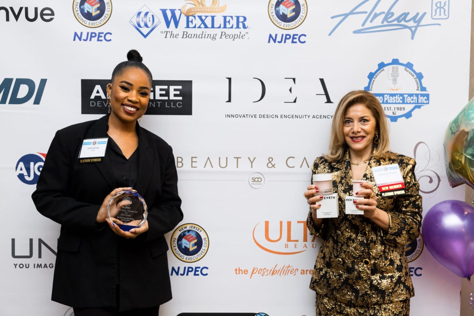 Two women holding awards at an event.