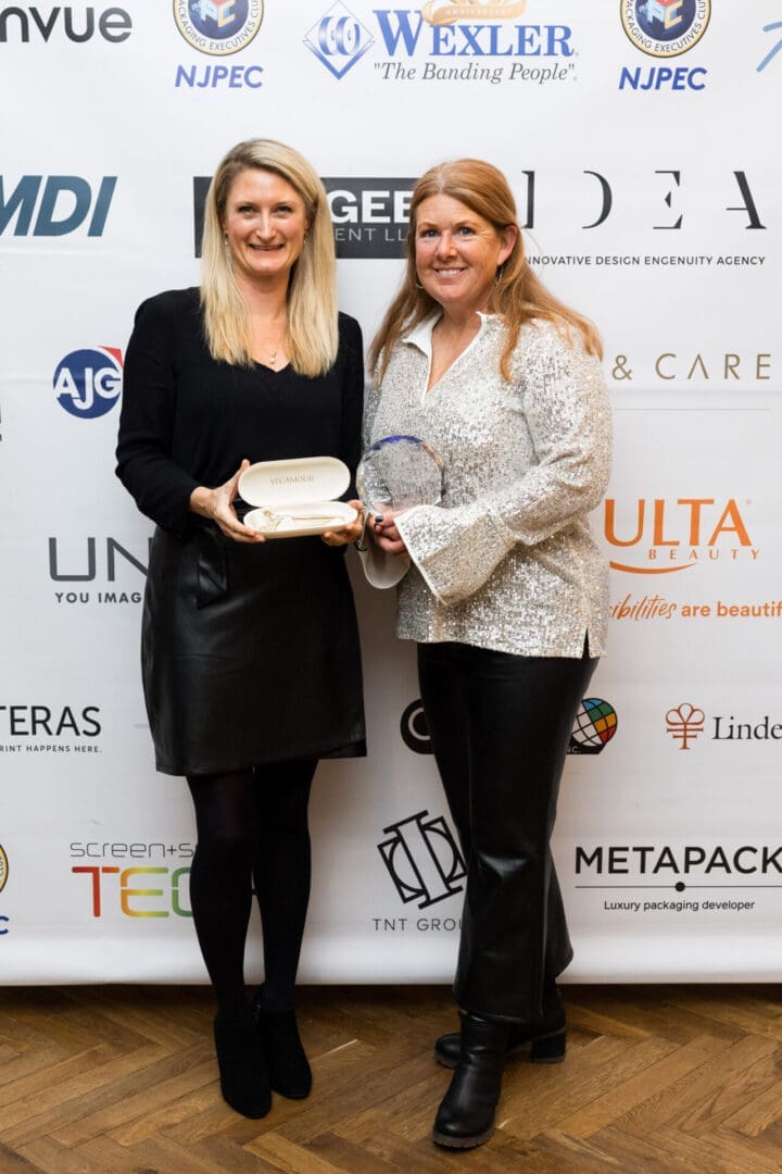 Two women holding awards at event.