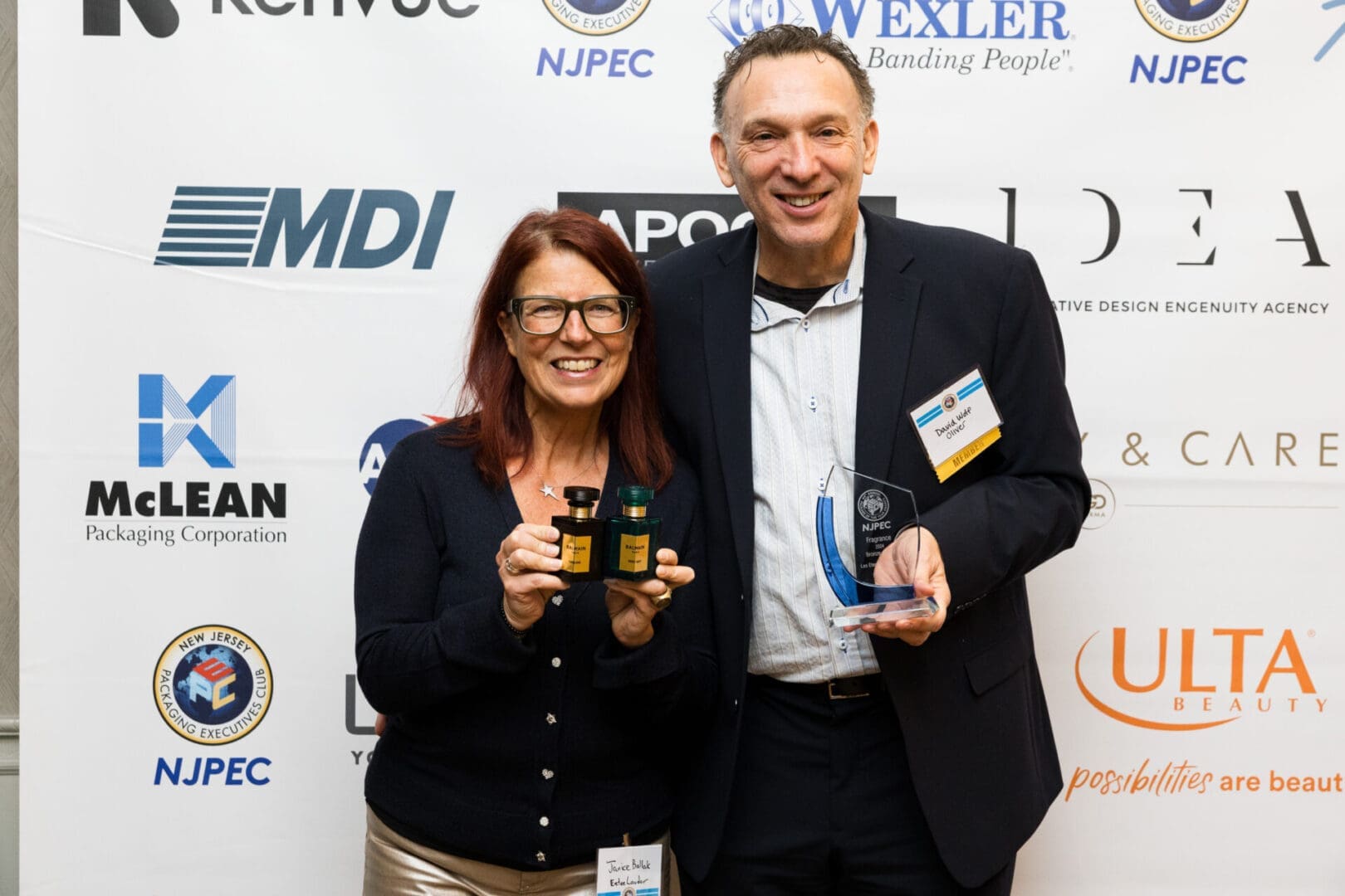 Two people holding awards at an event.