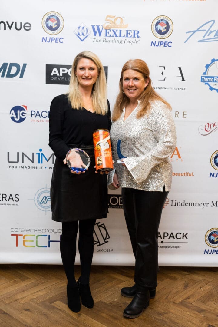 Women holding awards at a network event.