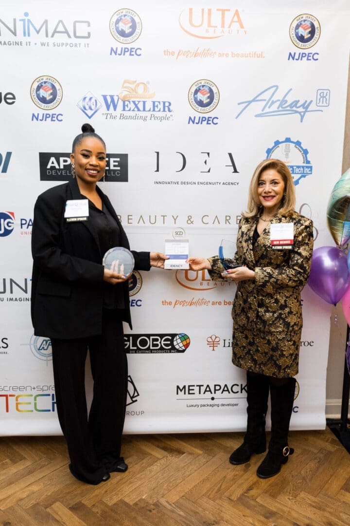 Two women holding an award plaque together.