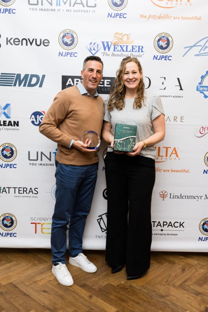 Two people holding awards at an event.