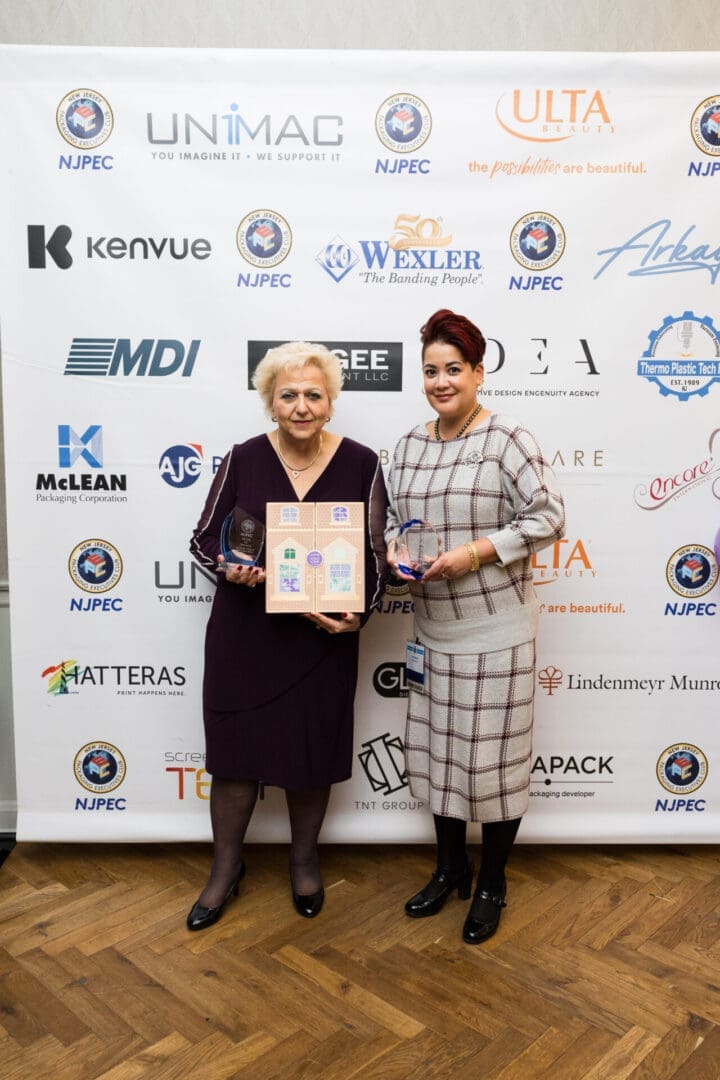Two women holding awards at an event.