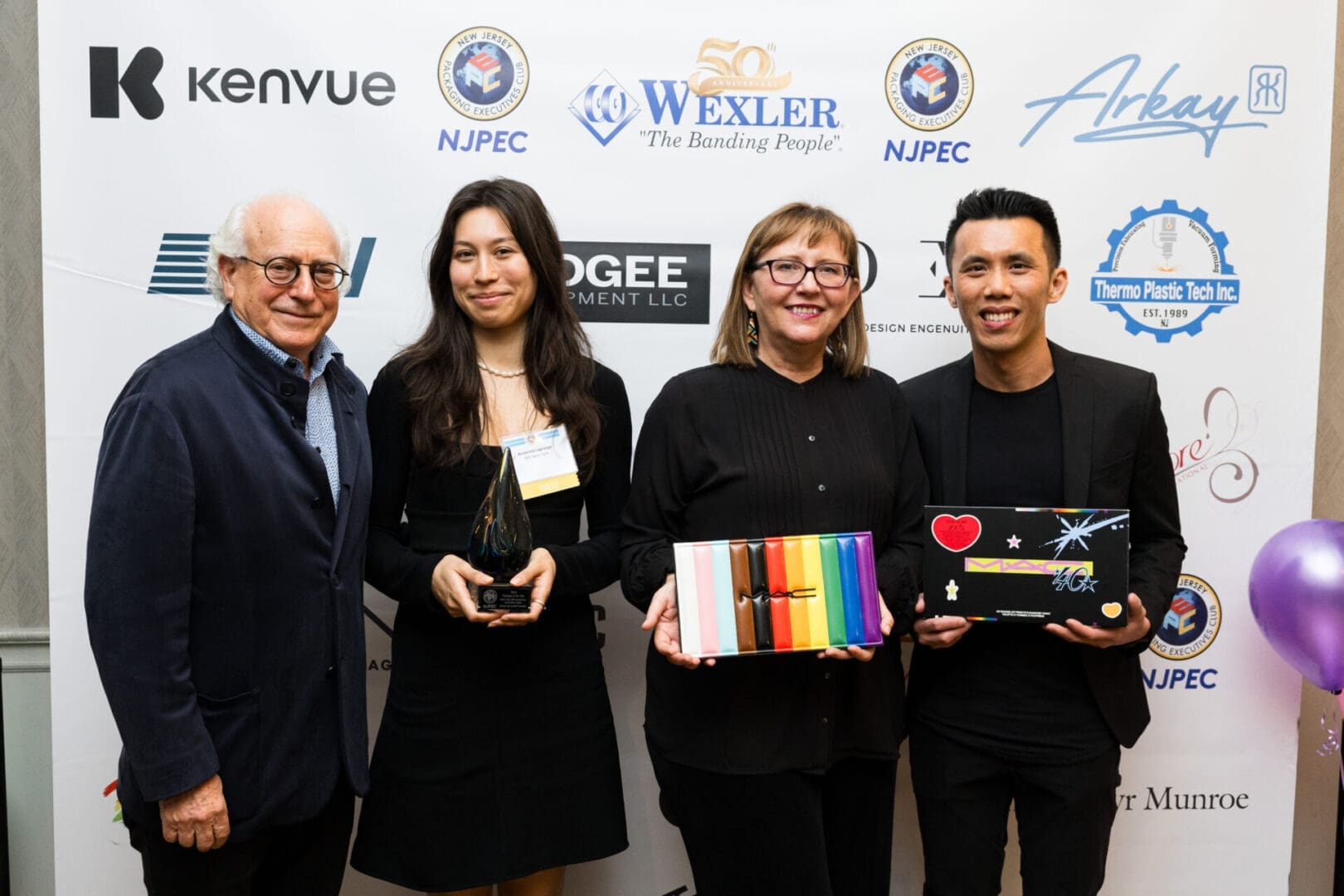Event attendees displaying awards and gifts.