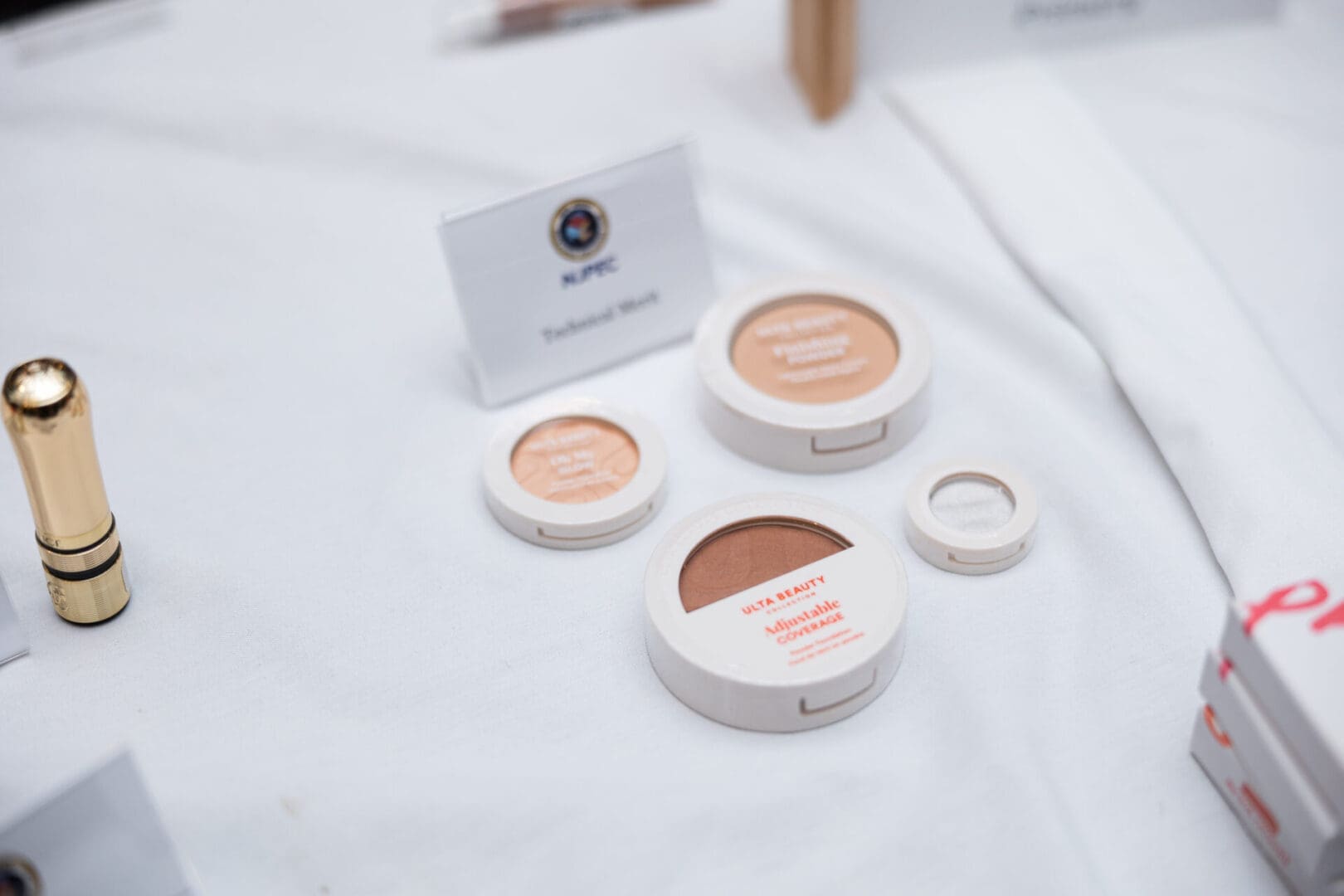 Makeup products on a white tablecloth.