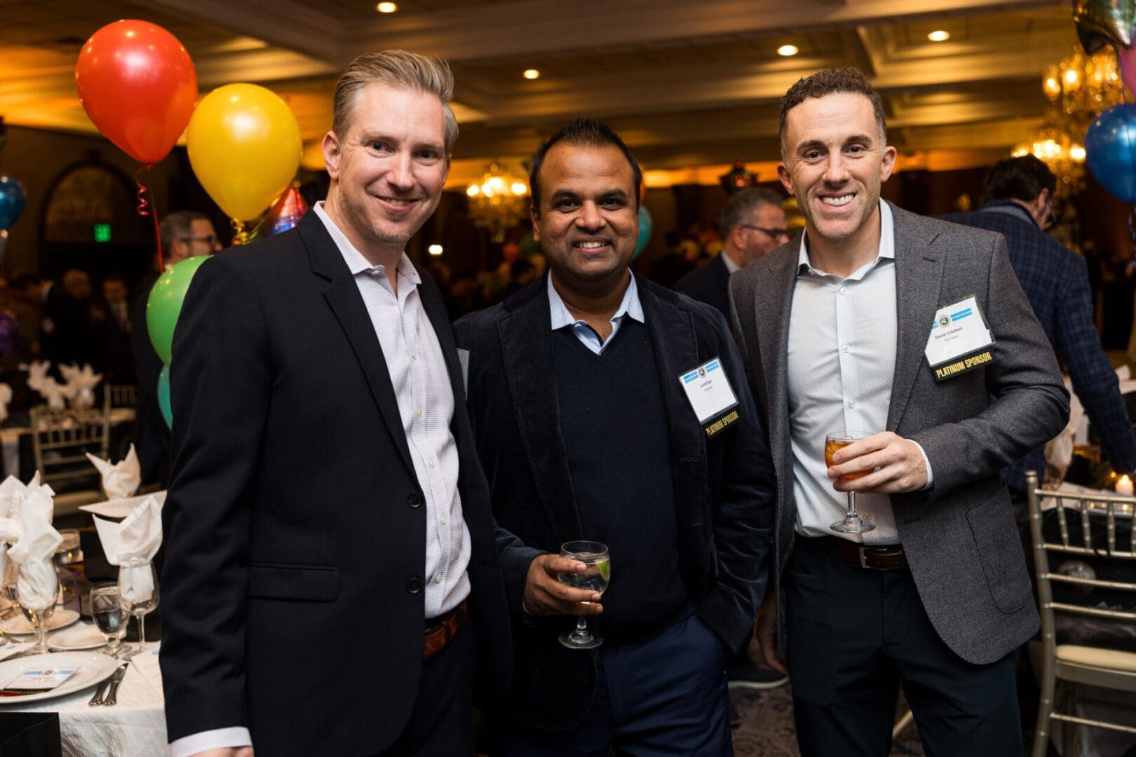 Three men posing at a festive event.