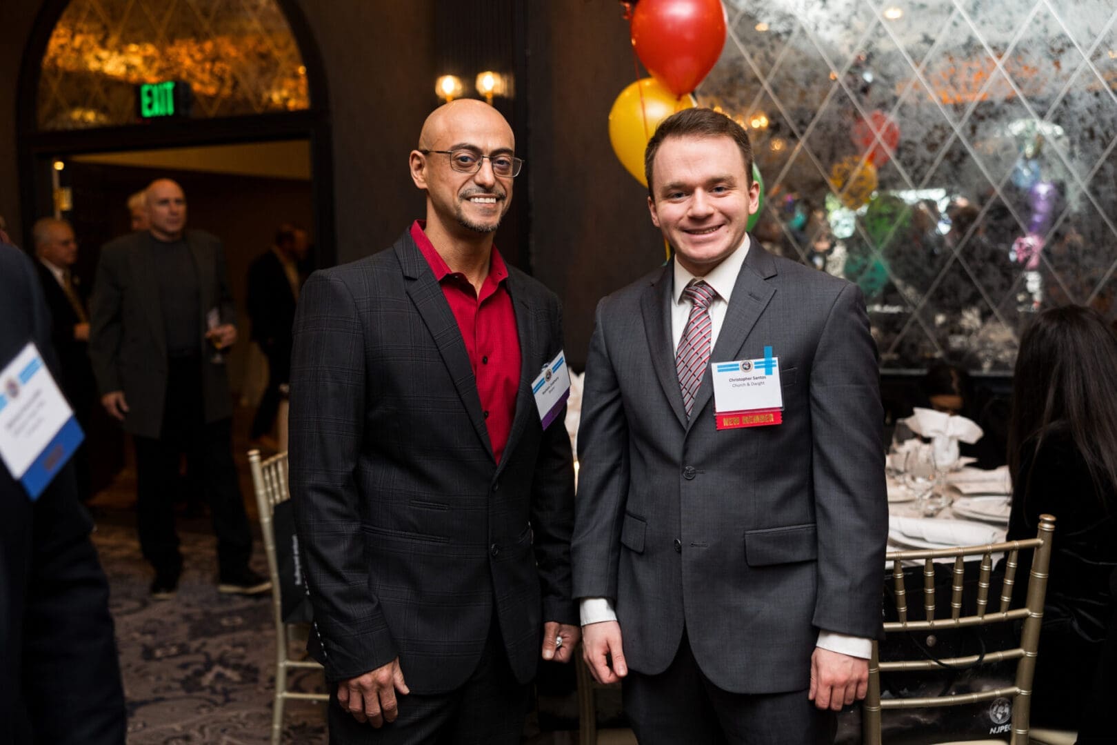 Two men smiling at a formal event.
