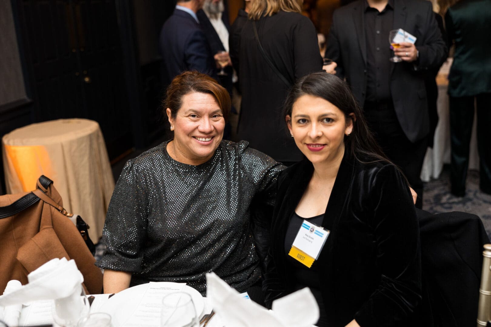 Two women smiling at a dining table.